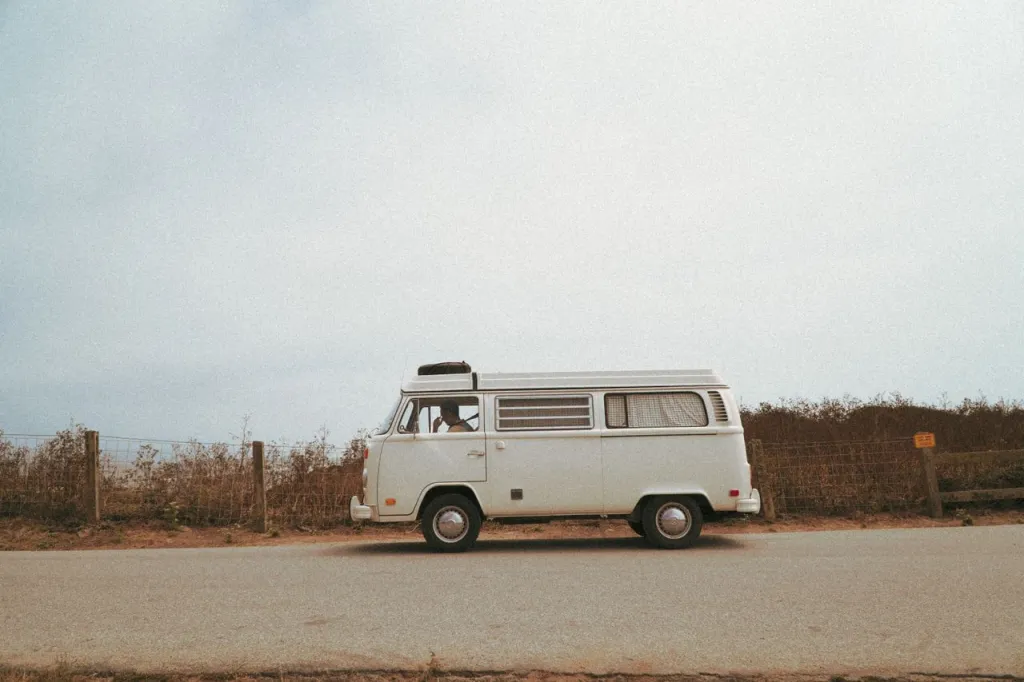 White Volkswagen Kombi campervan parked on a quiet roadside
